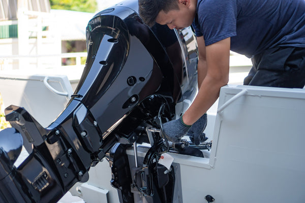 Marine technician working on a boat engine in a marina service bay